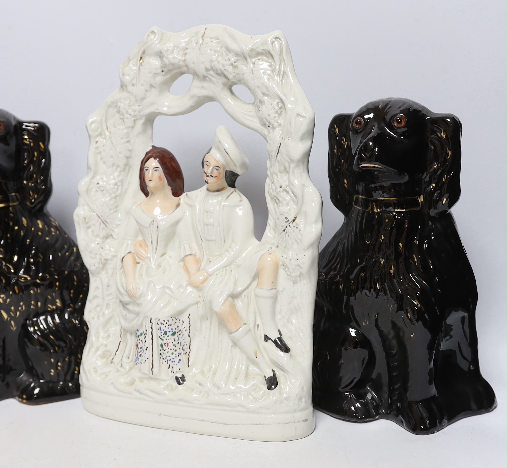 A Staffordshire watch-stand figural group, pair of comforters and two others, largest 34cm high